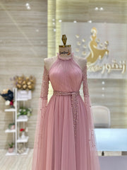 A soft peach, single-cloche dress with elegant sleeves, perfect for a family gathering.
